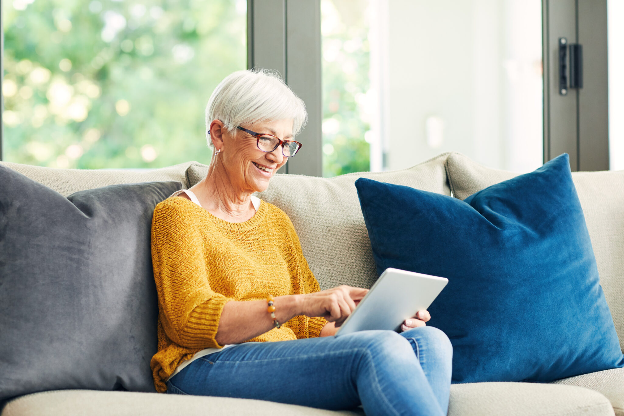 Shot of a senior woman using a digital tablet on the sofa at home