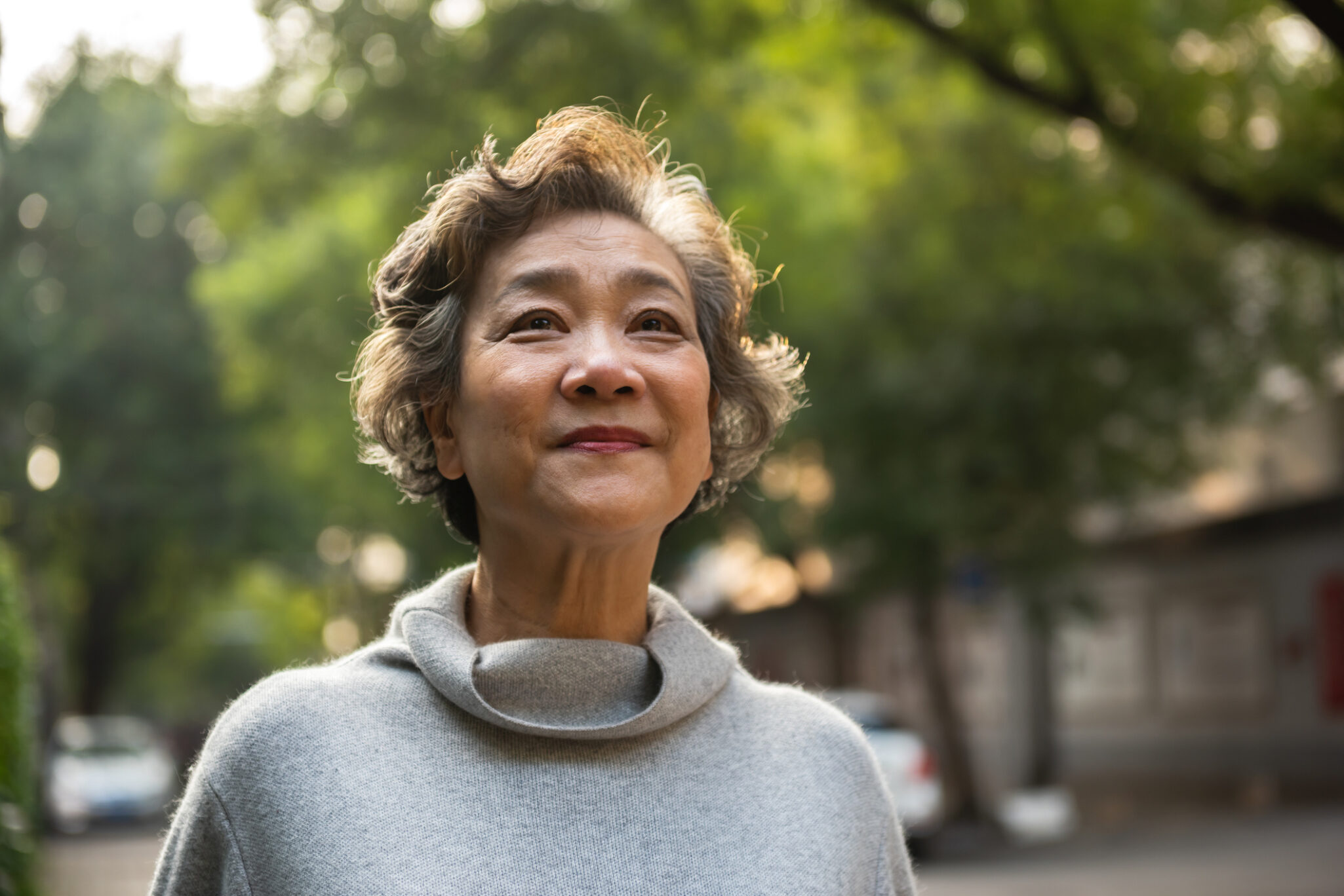 A smiling older woman outside