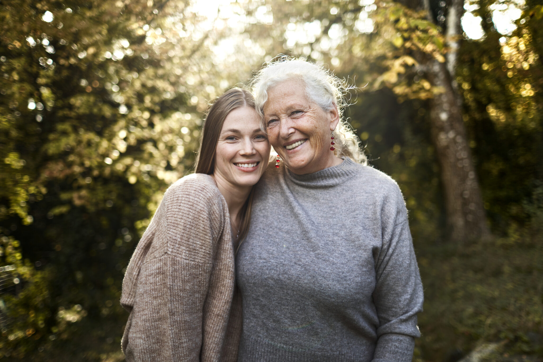Portrait of happy grandmother and adult granddaughter in garden