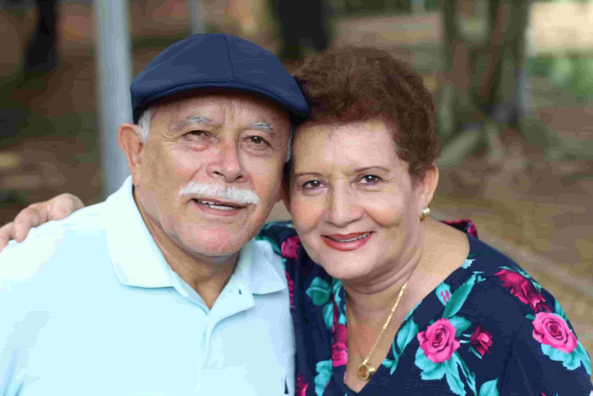 An elderly couple hugging and smiling for the camera